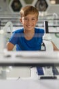 Portrait of smiling caucasian elementary schoolboy sitting at desk in science laboratory Royalty Free Stock Photo