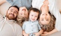 Portrait of smiling caucasian family of four from above lying and relaxing on floor at home. Faces of carefree loving Royalty Free Stock Photo