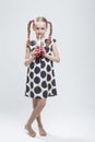 Portrait Of Smiling Caucasian Little Girl With Pigtails Standing Barefoot in Polka Dot Dress