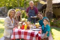 Portrait of smiling caucasian three generational family eating barbecue food in the garden Royalty Free Stock Photo