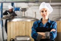 Portrait woman brewer standing in workshop of beer factory