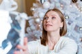 Portrait of smiling caucasian woman holding silver gift box near tree. A young Royalty Free Stock Photo