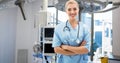 Portrait of smiling caucasian young female doctor with arms crossed standing in hospital ward Royalty Free Stock Photo