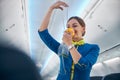 Air hostess showing how to use an oxygen mask on board