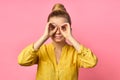 Portrait of a smiling cheerful girl in summer clothes looking far away with hand at her forehead isolated over pink Royalty Free Stock Photo