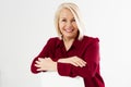 Portrait of smiling cheerful happy middle-aged blonde woman sitting on chair isolated on white Royalty Free Stock Photo