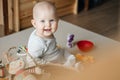 Portrait of a smiling child playing with toys while sitting on the floor in the nursery on the mat. Royalty Free Stock Photo