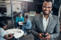 Portrait of a smiling confident black businessman holding his mobile phone Royalty Free Stock Photo