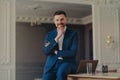 Portrait of smiling confident businessman sitting on office desk Royalty Free Stock Photo