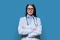 Portrait of confident female doctor looking at camera on blue background Royalty Free Stock Photo