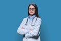 Portrait of confident female doctor looking at camera on blue background Royalty Free Stock Photo