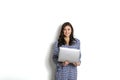 Portrait, smiling confident pretty woman long sleeve dress, holding grey laptop device and typing while standing against solid whi Royalty Free Stock Photo