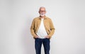 Portrait of smiling confident senior businessman with hands in pockets posing on white background Royalty Free Stock Photo