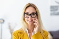 Portrait of smiling confident woman executive standing in modern office, talking on mobile phone Royalty Free Stock Photo