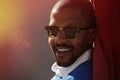 Portrait of smiling confident young African-American businessman in formal wear and sun glasses in city park.Blurred Royalty Free Stock Photo