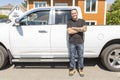 Portrait of a smiling construction worker in hardhat standing next to truck on construction site Royalty Free Stock Photo