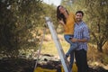 Portrait of smiling couple with ladder at olive farm