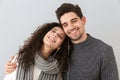 Portrait of smiling couple man and woman listening to music together with earphones, isolated over gray background Royalty Free Stock Photo