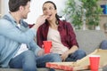 portrait smiling couple with pizza on sofa at home Royalty Free Stock Photo