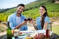 Portrait of smiling couple toasting red wine glasses while sitting at table Royalty Free Stock Photo