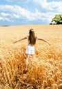 Portrait of smiling cute little girl child running through field of wheat Royalty Free Stock Photo