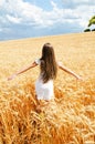 Portrait of smiling cute little girl child running through field of wheat Royalty Free Stock Photo