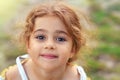 Portrait of smiling cute little girl at green of summer park. Happy child looking at the camera Royalty Free Stock Photo