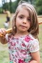 Portrait of smiling cute little girl playing with an old tennis racket in a public park Royalty Free Stock Photo