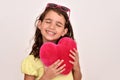 Young girl with closed eyes hugging plush red heart Royalty Free Stock Photo