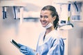 Smiling dental assistant using digital tablet