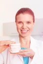 Portrait of smiling dentist holding dentures at clinic