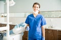 Portrait Of Smiling Dentist In Scrubs At Clinic