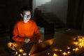 Portrait of smiling designer girl, working at graphic tablet on laptop. Wearing eyeglasses and orange sweater. In dark room home. Royalty Free Stock Photo