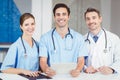 Portrait of smiling doctor and colleagues holding digital tablet Royalty Free Stock Photo