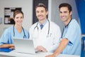 Portrait of smiling doctor and colleagues with laptop Royalty Free Stock Photo