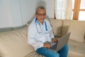 Portrait of a smiling doctor in conversation through a laptop in the clinic`s office