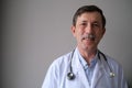 Portrait of a smiling doctor in front of gray background Royalty Free Stock Photo