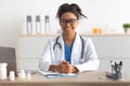 Portrait of smiling doctor looking at camera sitting at desk Royalty Free Stock Photo