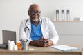 Portrait of smiling doctor looking at camera sitting at desk Royalty Free Stock Photo