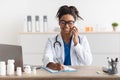 Portrait of smiling doctor talking on phone working at clinic Royalty Free Stock Photo