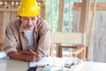 Portrait of smiling elderly carpenter working at wooden desk with different craft tools, enjoying his DIY hobby, senior craftsman Royalty Free Stock Photo