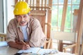 Portrait of smiling elderly carpenter working at wooden desk with different craft tools, enjoying his DIY hobby, senior craftsman Royalty Free Stock Photo