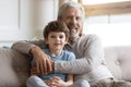 Portrait of elderly grandfather and little grandson hugging