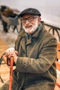 Portrait of a smiling elderly man sitting on bench in park Royalty Free Stock Photo