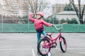 Preschooler girl riding pink bike bicycle in helmet on backyard road outside on spring autumn day Royalty Free Stock Photo