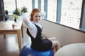 Portrait of smiling executive exercising on fitness ball