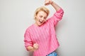 Portrait of smiling face blond young woman clenching fists and rejoicing, celebrating victory isolated on white studio background Royalty Free Stock Photo