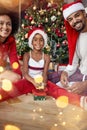 Portrait of family exchanging gifts in front of Christmas tree Royalty Free Stock Photo