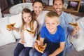 Portrait of smiling family holding pizza slices while sitting on sofa Royalty Free Stock Photo