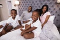 Portrait of smiling family sitting on bed Royalty Free Stock Photo